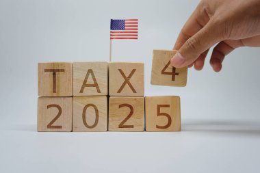 Image of wooden blocks spelling 'Tax 2025' with a small American flag, symbolizing future tax seasons and preparations clipart