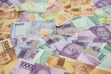 Endonezya para birimi notları, renkli bir dizi ve bankacılık, finans ve yatırım kavramlarını canlı ve göz alıcı bir kompozisyonda temsil eden rastgele yayılmış banknotlar sergiliyor..