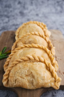 Kue Pastel ya da Jalangkote, Endonezya 'nın geleneksel çerezleri taze yeşil biberli ahşap kesim tahtasında servis edilen havuç ve patateslerle dolu.