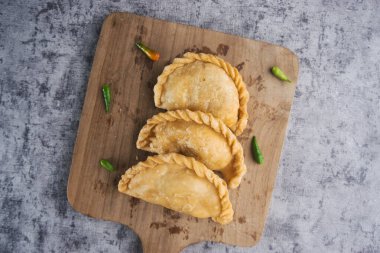 Kue Pastel ya da Jalangkote, Endonezya 'nın geleneksel çerezleri taze yeşil biberli ahşap kesim tahtasında servis edilen havuç ve patateslerle dolu.