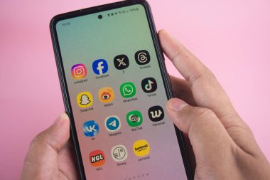 Sleman, Endonezya - 02 Ocak 2025: Ekranda Instagram, Facebook, X, Snapchat, Weibo ve TikTok gibi çeşitli sosyal medya uygulamalarını gösteren bir akıllı telefon tutan kişi. Modern teknoloji ve dijital iletişim