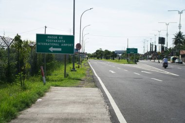 Yogyakarta Uluslararası Havalimanı 'nı gösteren yön işareti sakin, güneşli bir yol üzerinde sergilendi