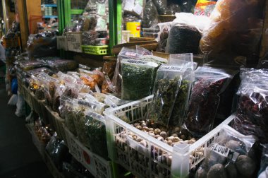 Etiketli çantalarda çeşitli kurutulmuş otlar ve malzemeler Beringharjo geleneksel pazarında düzenli bir şekilde sergilenmektedir.