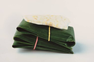 Geleneksel muz yaprağı ambalajı içinde sunulan sağlıklı Endonezya tempehinin yakın çekim görüntüsü