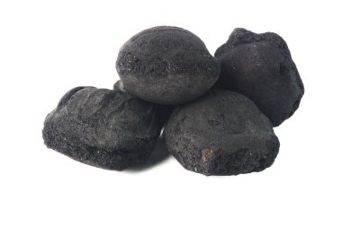 Beyaz bir arka planda, ızgara veya barbekü için uygun siyah kömür briketlerinin yakın plan görüntüsü