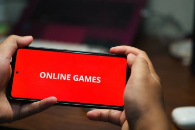 Akıllı telefonu yatay olarak tutan eller kırmızı arkaplanlı 