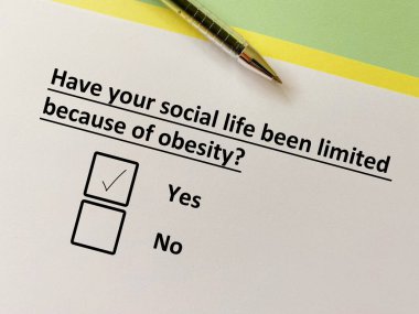 Bir kişi diyetle ilgili soruya cevap veriyor. Sosyal hayatı obezite yüzünden kısıtlı..