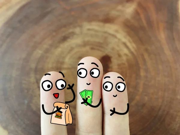 Three fingers are decorated as three person. One of them is delivering food to another two.