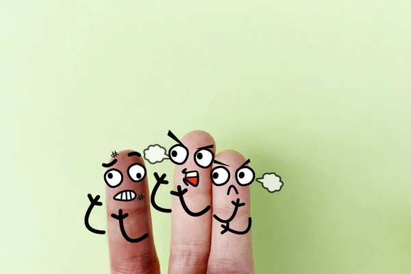 Three fingers are decorated as three person. One of them are bullied by another two.
