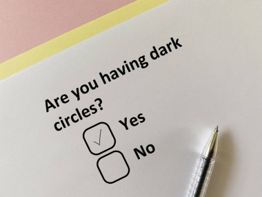 Bir insan deri sorunuyla ilgili soruya cevap veriyor. Siyah halkalar takıyor..