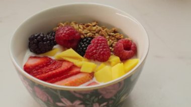 Bir kase yoğurt, meyve ve granola.
