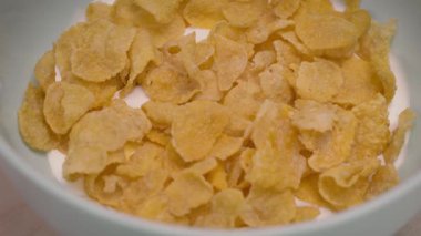 Mısır gevreği dokusunu bir kasede yavaşça dönen sütle birlikte dikkatlice yaklaşır..