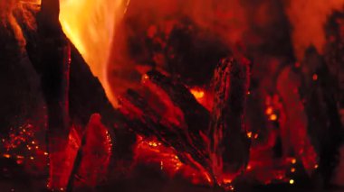 Yoğun ateş kömürü yakar, kıpkırmızı yakar, detaylıca görünür, kıvılcımlar yanarken