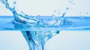 Buzun suya nasıl düştüğünü, beyaz bir arkaplanın önüne nasıl atladığını, yavaş çekimde.