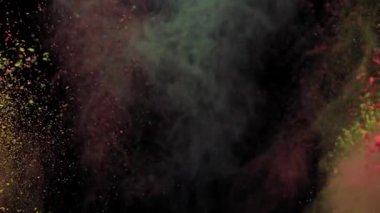 Renkli tozların renkli patlaması, yavaş çekim videosunda siyah arka planda sarı ve mavi.