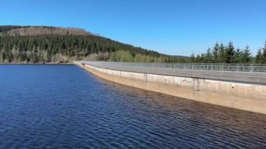 Çoğu Çek Cumhuriyeti - 27 Nisan 2025 Flaje barajlarının sakin, derin mavi suları, yoğun yeşil ormanlarla çevrili ve açık mavi gökyüzü altında yuvarlanan tepeleri tutan huzurlu manzarası