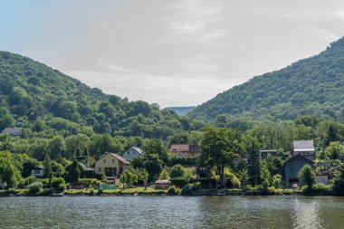 Usti Nad Labem, Çek Cumhuriyeti - 22 Haziran 2025: Elbe Nehri kıyısında yemyeşil tepeli Usti Nad Labem manzarası