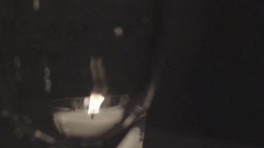 Şarap kadehinden romantik mum ışığı.