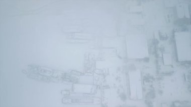 Karlı bir kış günü, gemilerin buz içinde donduğu tersanenin tam üstünde bir dron ile uçmak. Yüksek kaliteli FullHD görüntüler