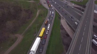 Akşamüstü trafiğin yoğun olduğu bir kavşakta bisikletçiler bisiklet yolunda giderken alçak açılı drone uçuşu. Ulaşım ve altyapı. Yüksek kalite 4k görüntü