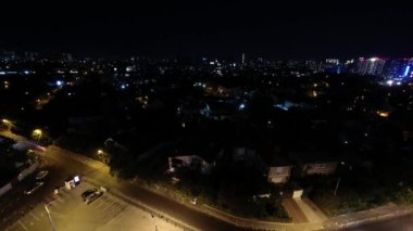 Gece şehri, evlerin ışıkları, geçen arabalar ve gece gökyüzünde bulutlar. Yüksek kaliteli FullHD görüntüler