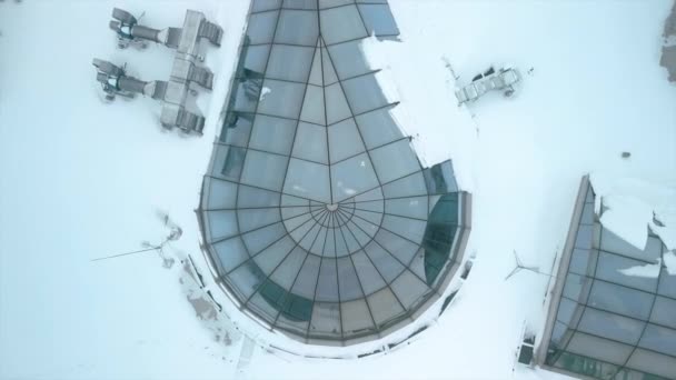 冬は雪に覆われたエンジニアリング機器をチェックする労働者としてショッピングモールの屋根の上を飛んでいます 高品質のフルHd映像 — ストック動画