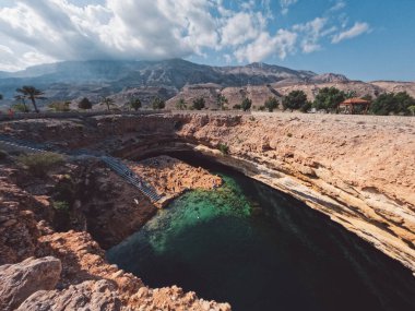 Bimmah, Oman, Bimmah Sinkhole in Oman, where fresh and salt water combine. Beautiful turquoise blue splendour. 600 meters separate the northeast coast of Oman. People spimming and relaxing. clipart