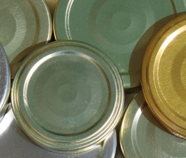 stock market traded raw materials, commodities, hard commodity close-up: silver golden, green, blue, metallic metal lids, lid trading, recycling, business folder, exchange, futures contract. sun, ship import export transportation cargo shipping