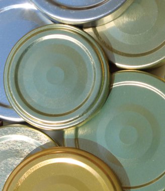 stock market traded raw materials, commodities, hard commodity close-up: silver golden, green blue metallic metal lids, lid trading, recycling, business folder, exchange, futures contract. sunshine, ship import export transportation cargo shipping