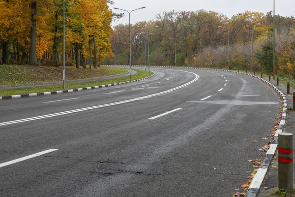 Otoyolda keskin bir dönüş, yol işaretleri ve direklerde yansıtıcı işaretler var..