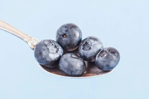 Gümüş kaşıkta yaban mersini. Sağlıklı gıda konsepti.