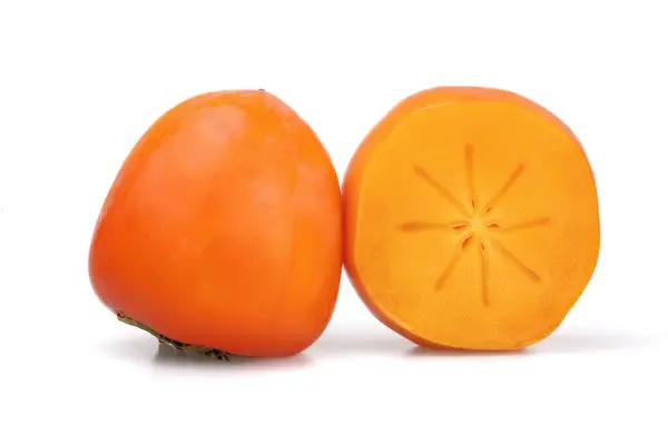 Beyaz arka planda yarıya kesilmiş olgun hurma meyveleri