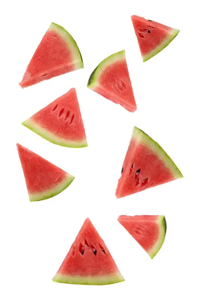 Beyaz arka planda süzülen olgun karpuz dilimleri..