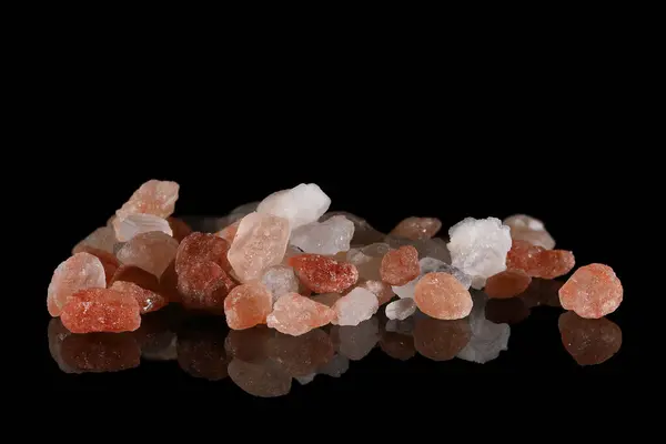 Siyah ayna yüzeyinde pembe Himalaya tuzu.