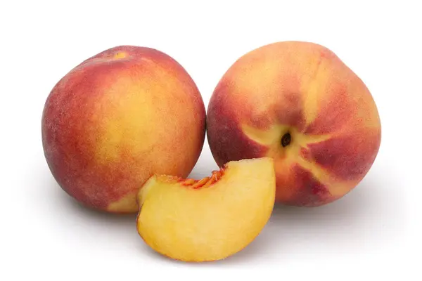 İki olgun şeftali ve beyaz arka planda izole edilmiş bir dilim..