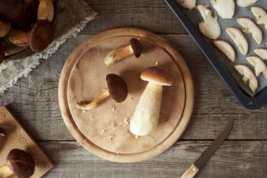 Taze porcini ve çam mantarı ahşap bir masada, üst manzara.