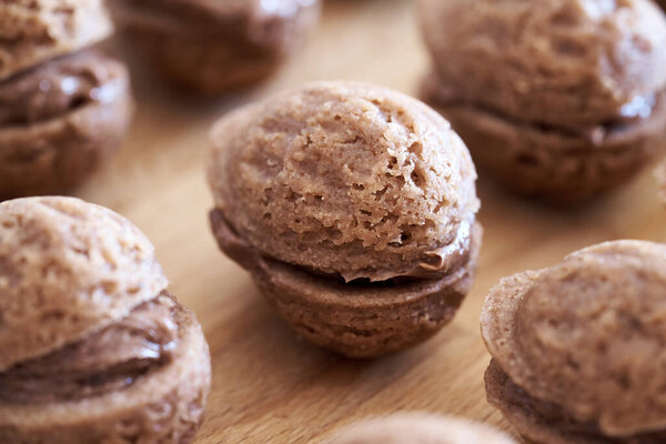 Homemade Christmas cocoa cookies in the form of nuts filled with chocolate cream, close up