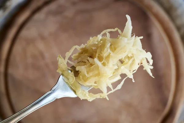 stock image Homemade fermented cabbage or sauerkraut on a fork, top view