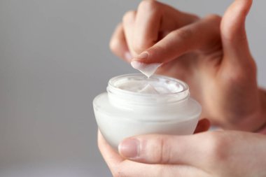 Female hands holding a jar of cosmetic cream