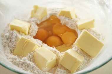 Pieces of butter and wheat flour in a glass bowl - preparation for baking cookies