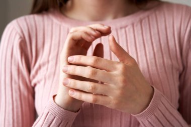 Young girl practicing EFT or emotional freedom technique - tapping on the karate chop point, close up