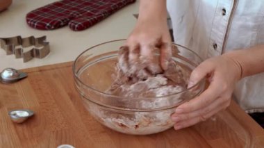Woman kneading dough to prepare homemade nut shaped Christmas cookies