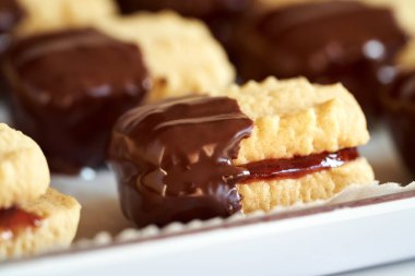 Çilekli marmelatla doldurulmuş ve çikolataya batırılmış bir Noel kurabiyesi.