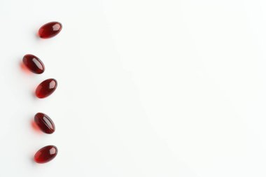 Kırmızı kril yağ hapları ya da beyaz arkaplanda fotokopi alanı olan küreseller