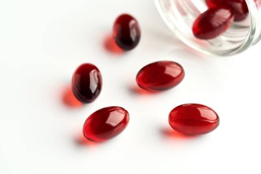 Red krill oil pills on white background. Healthy nutritional supplement. clipart