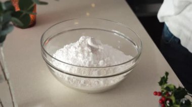 Pouring vanilla sugar into a bowl - preparation of dough for Christmas cookies