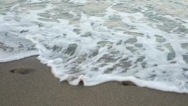 Zee Golven Wegspoelen Menselijke Voetafdrukken Het Strand — Stockvideo