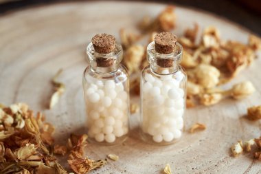 Kurutulmuş otlarla birlikte iki şişe homeopatik ilaç. Alternatif tıp.