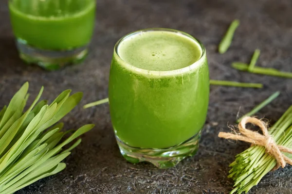 自家製のブレードを持つ新鮮な緑の大麦の草ジュースのガラス — ストック写真