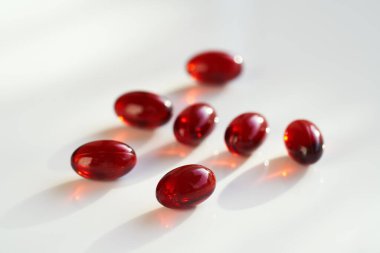 Beyaz arkaplandaki kırmızı krill yağ kürelerinin yakınlaştırılması